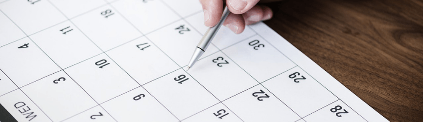 Person writing notes on a calendar